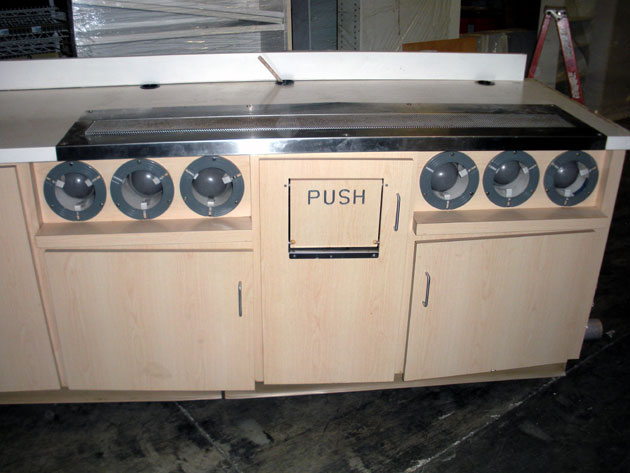 detail of cup dispensers and trash recepticle on large food and beverage counter